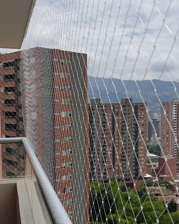 Malla de seguridad monofilamento transparente instalada en balcón de apartamento en Medellín